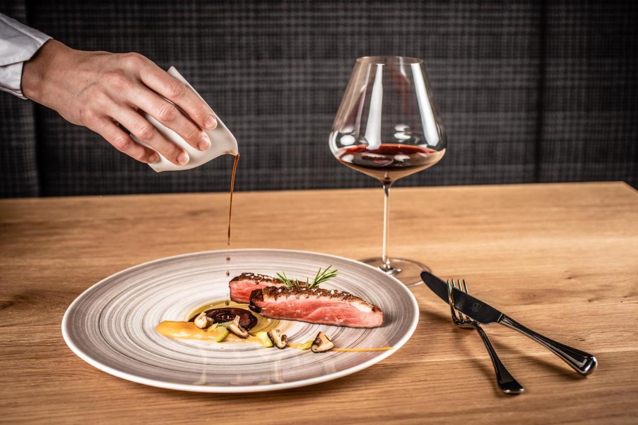 My Arbor - Dolomites Hotel Bressanone Bagian luar foto A server pouring sauce onto a prepared dish