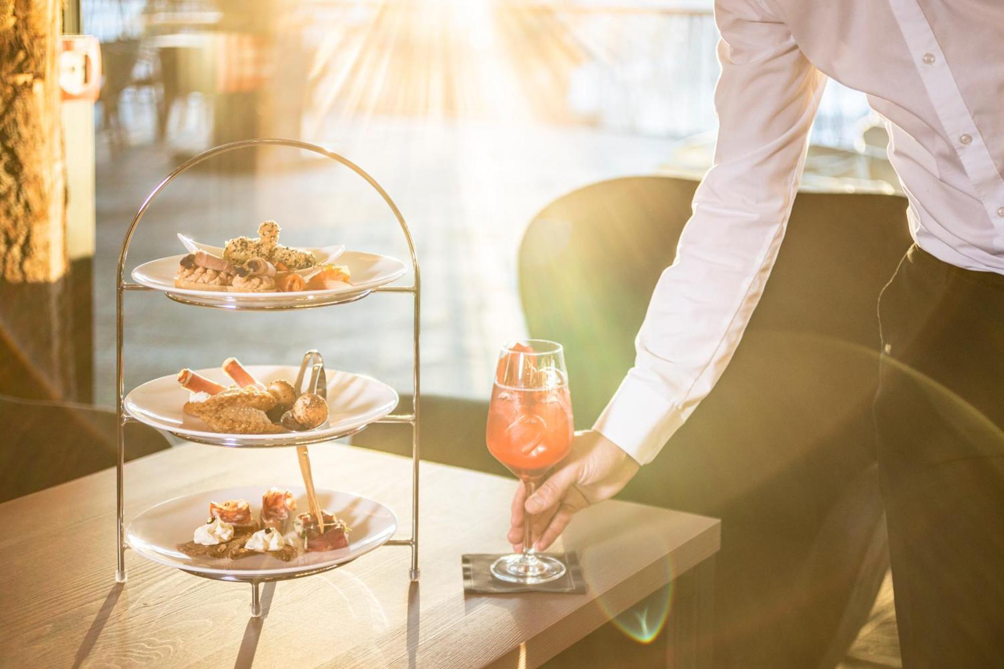 My Arbor - Dolomites Hotel Bressanone Bagian luar foto A waiter serving a drink